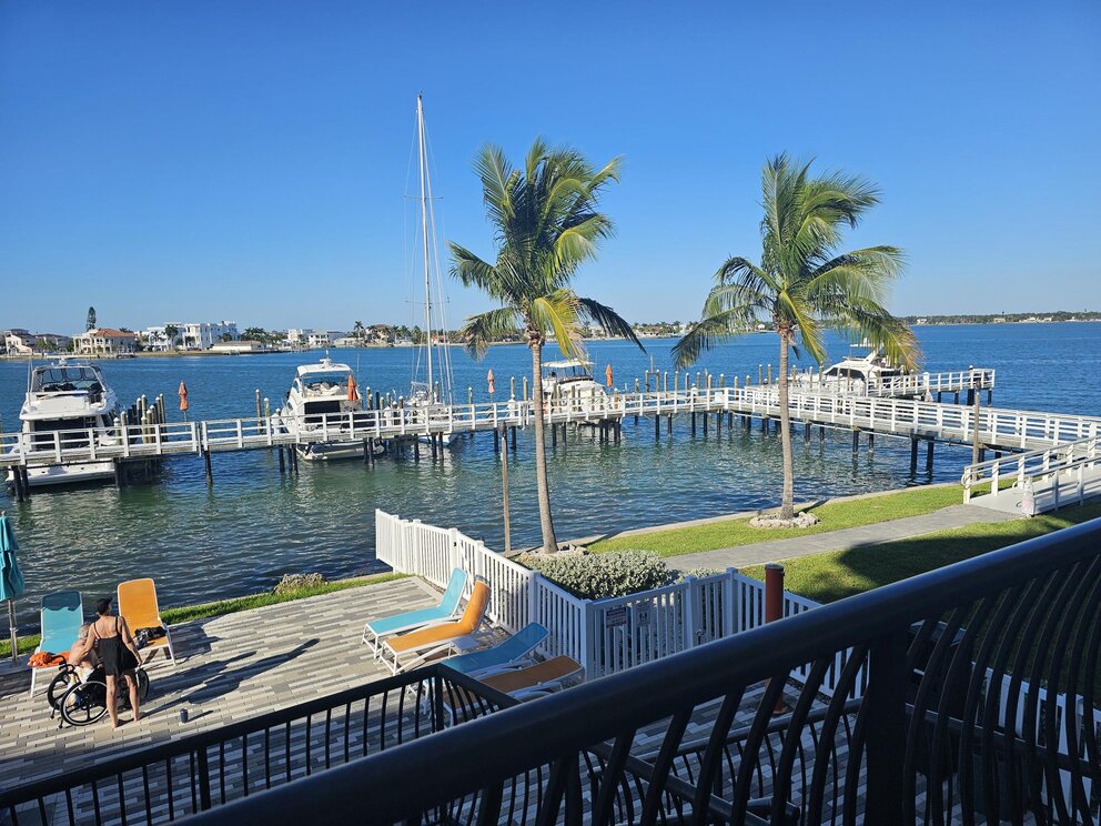 a deck with chairs and a dock on the water